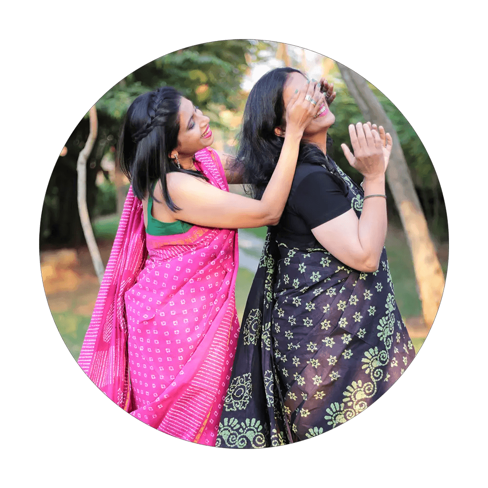 Two female models playing in a garden wearing Pink and Green sarees respectively from Luka Chuppi collection of Seven Sarees.