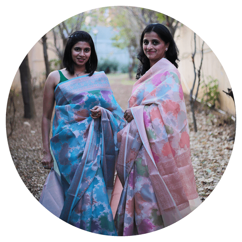 Two female models in a garden wearing blue and pink organza saree respectively from Mohe Rang De collection of Seven Sarees.